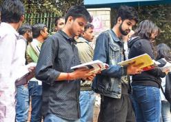 সামনে পরীক্ষা, এটিএমের লাইনে দাঁড়িয়েই বইয়ে চোখ পড়ুয়াদের